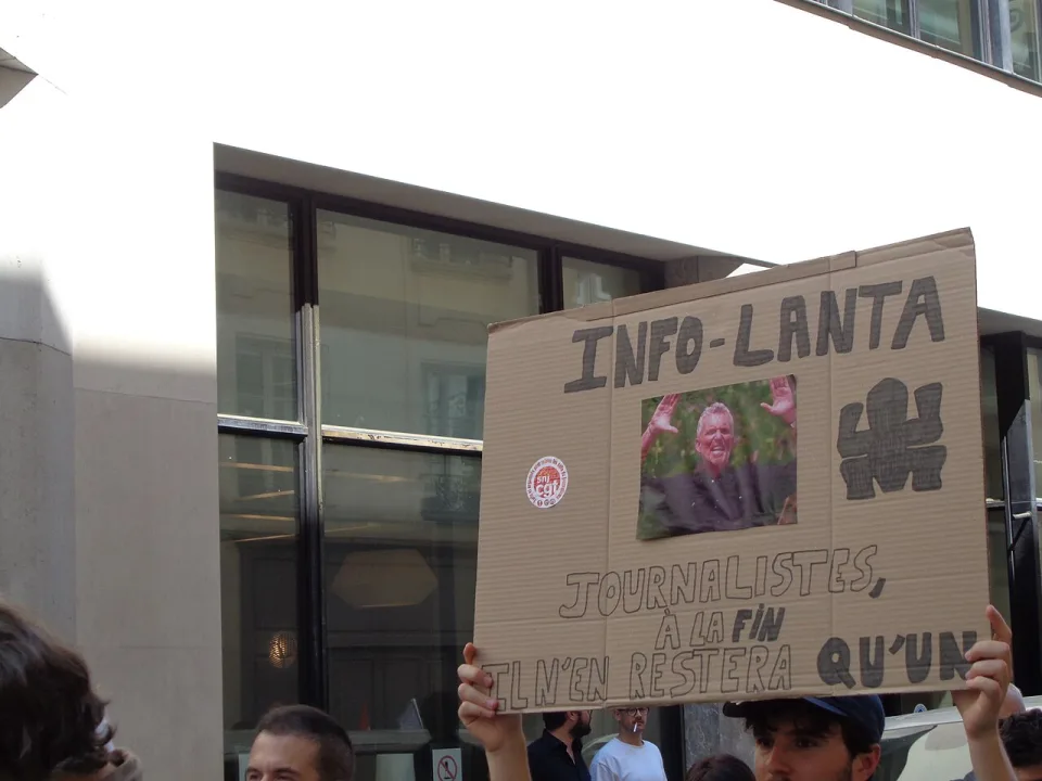 Protest sign reading “Info-Lanta : journalistes, à la fin il n’en restera qu’un” at “Media independence demonstration — Paris, 18 June 2026” in Paris, France.