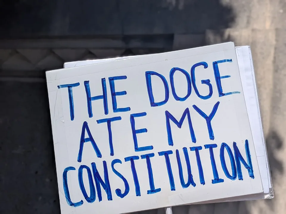 Protest sign reading “The DOGE ate my Constitution” at “No Kings in Berkeley — 28 March 2026” in Berkeley, United States.