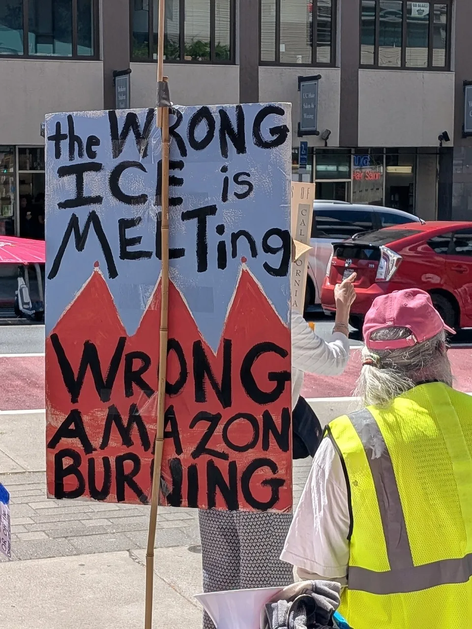 لافتة كُتب عليها «The wrong ICE is melting, wrong Amazon burning» خلال «لا ملوك في بيركلي — 28 مارس 2026» في Berkeley, الولايات المتحدة.