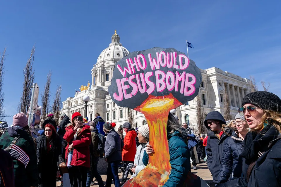 Protest sign reading “Who would Jesus bomb?” at “No Kings in Saint Paul — 28 March 2026” in Saint Paul, United States.