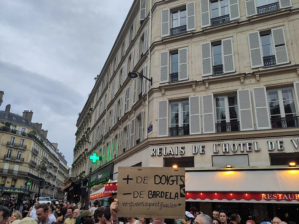 Pancarta con el texto «+ de doigts, − de Bardella» durante «Orgullo de París — 3 de octubre de 2026» en Paris, Francia.