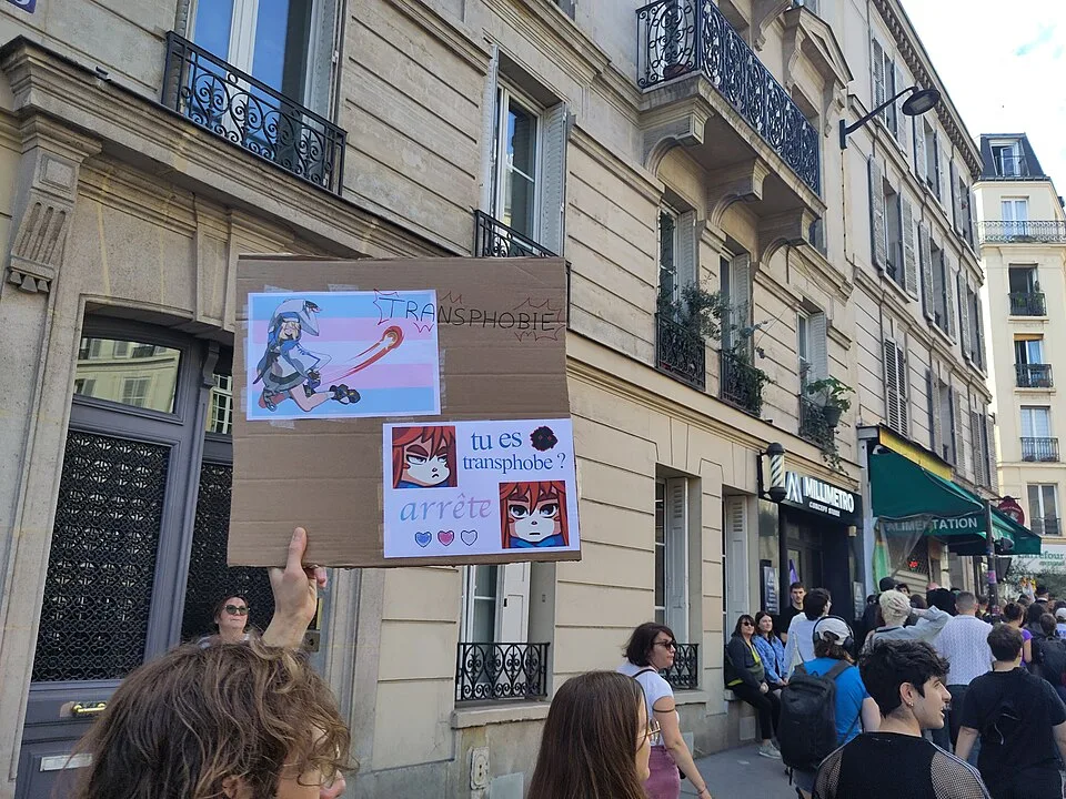 Pancarta con el texto «Tu es transphobe ? Arrête» durante «Orgullo de París — 3 de octubre de 2026» en Paris, Francia.