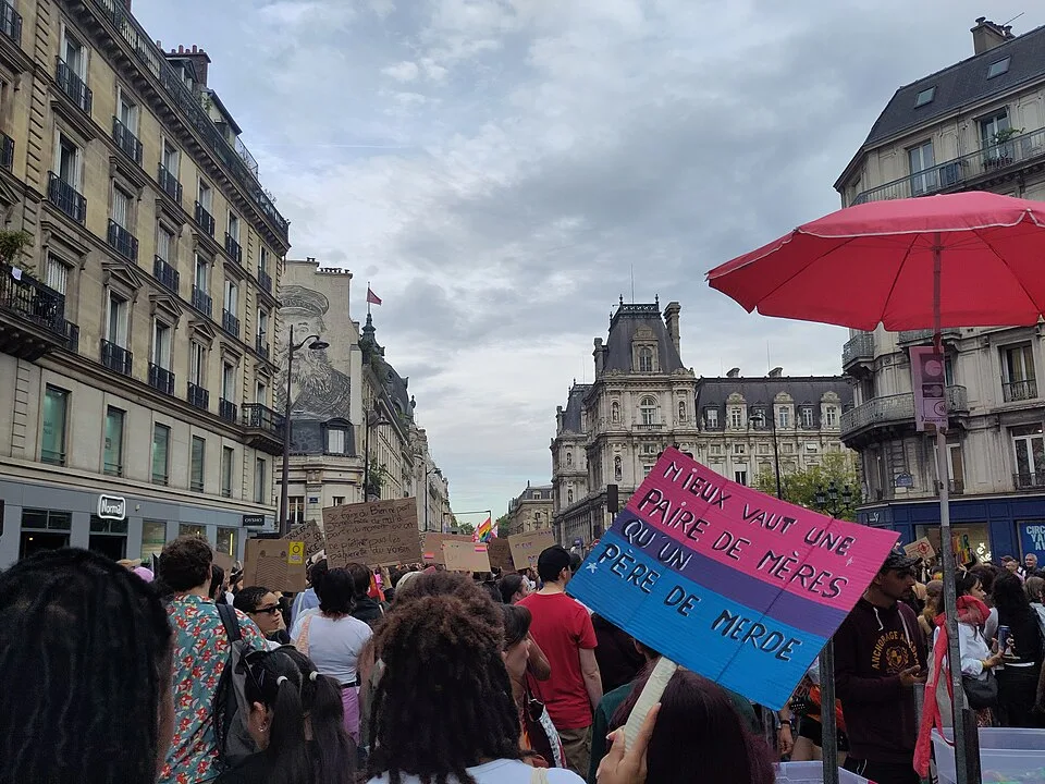 Protest sign reading “Mieux vaut une paire de mères qu’un père de merde” at “Paris Pride — 3 October 2026” in Paris, France.