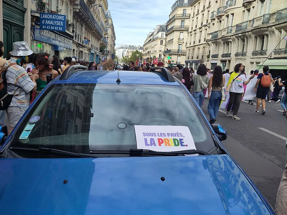 Protest sign reading “Sous les pavés, la Pride” at “Paris Pride — 3 October 2026” in Paris, France.