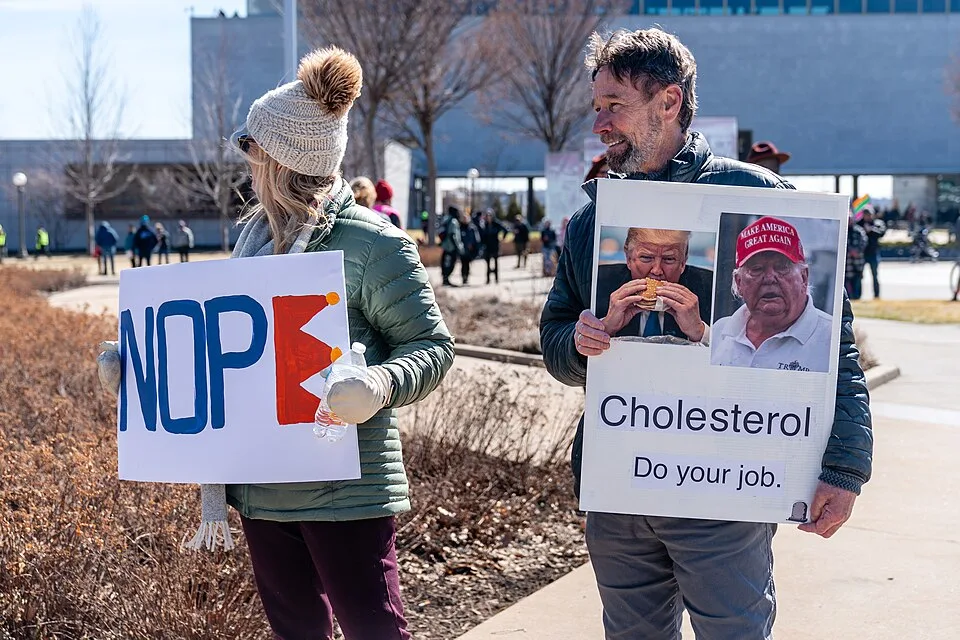 Protest sign reading “Cholesterol, do your job.” at “No Kings in Saint Paul — 28 March 2026” in Saint Paul, United States.