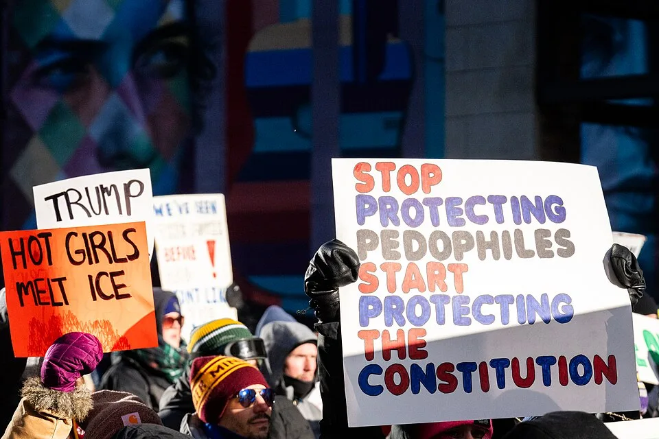Protest sign reading “Hot girls melt ICE”, photographed in Minneapolis, United States.