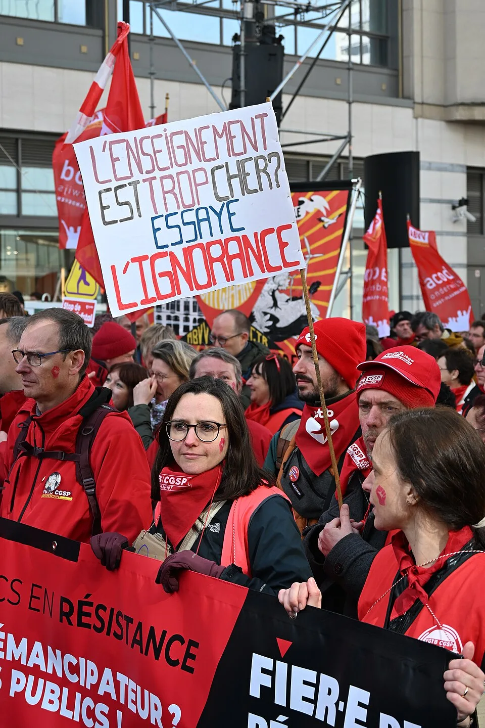 Protest sign reading “L’enseignement est trop cher ? Essaye l’ignorance” at “Protest against the De Wever government — Brussels, 12 March 2026” in Bruxelles, Belgium.
