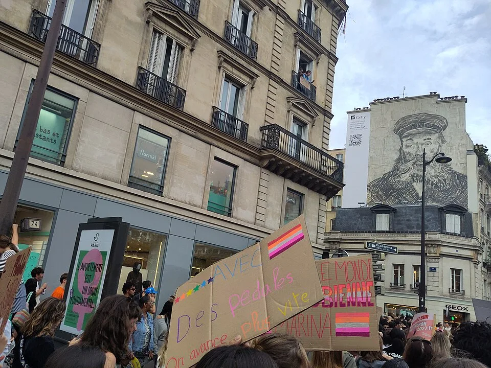 Protest sign reading “Avec des pédales, on avance plus vite” at “Paris Pride — 3 October 2026” in Paris, France.