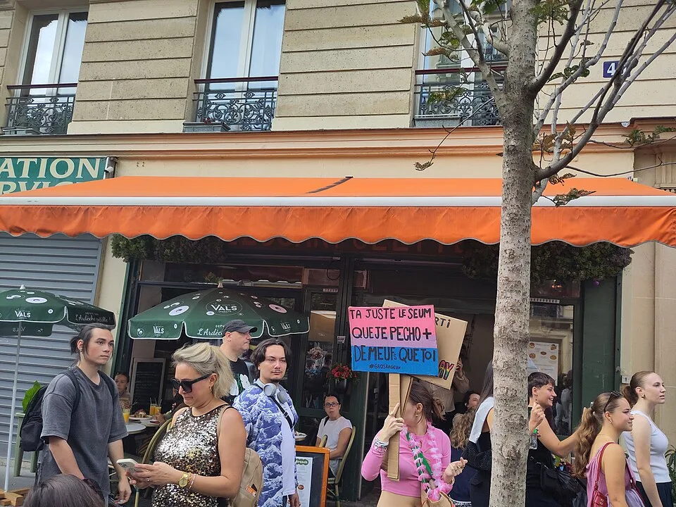 Protest sign reading “T'as juste le seum que je pécho plus de meufs que toi” at “Paris Pride — 3 October 2026” in Paris, France.
