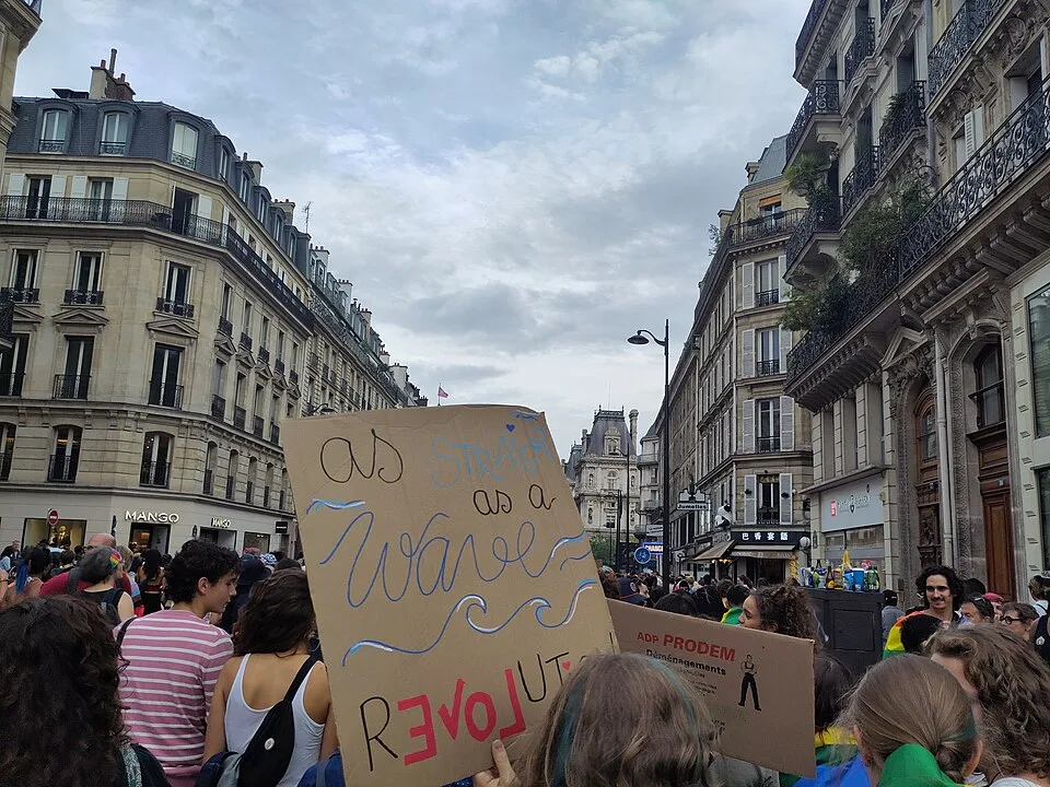 Protest sign reading “As straight as a wave” at “Paris Pride — 3 October 2026” in Paris, France.