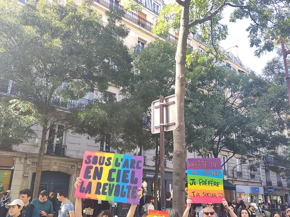 Protest sign reading “Arrête de me siffler, je préfère ta sœur” at “Paris Pride — 3 October 2026” in Paris, France.