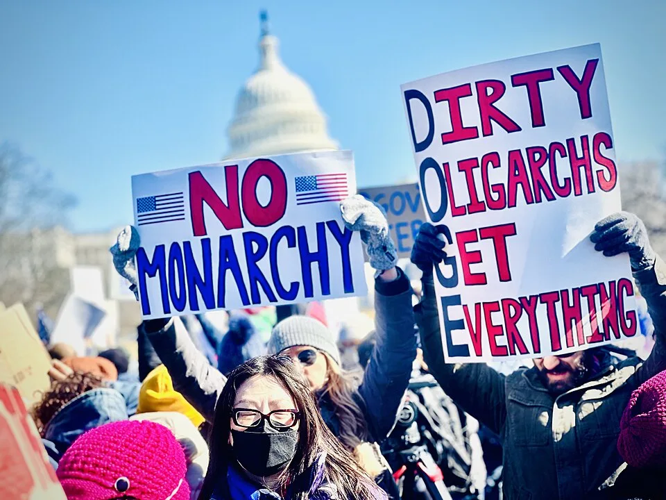Protest sign reading “Dirty Oligarchs Get Everything”