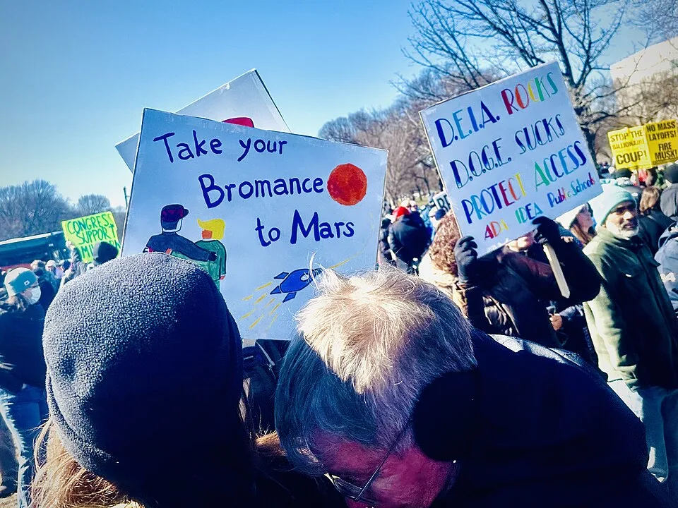 Protest sign reading “Take your bromance to Mars”