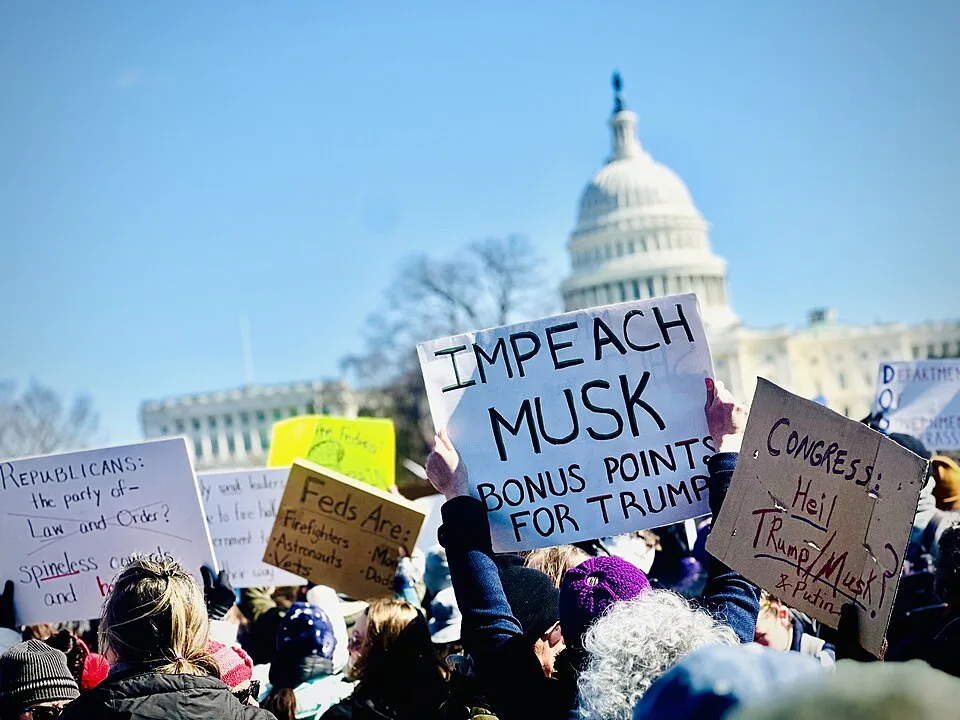 Protest sign reading “Impeach Musk. Bonus points for Trump”