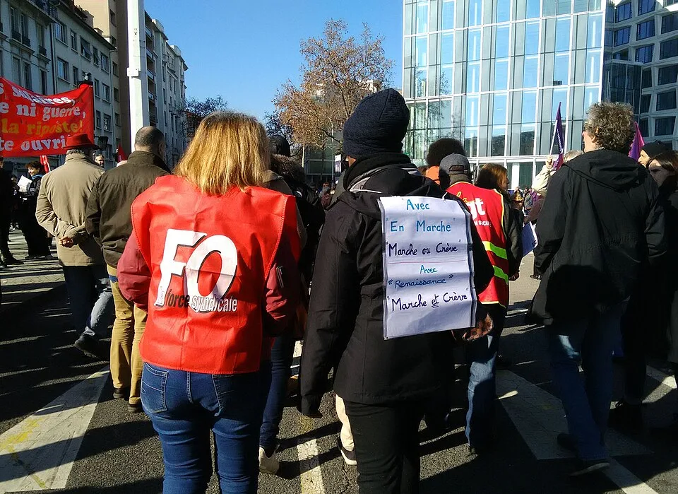 لافتة مظاهرة كُتب عليها «Avec En Marche, marche ou crève. Avec Renaissance, marche ET crève»، صُوّرت في Lyon, فرنسا.