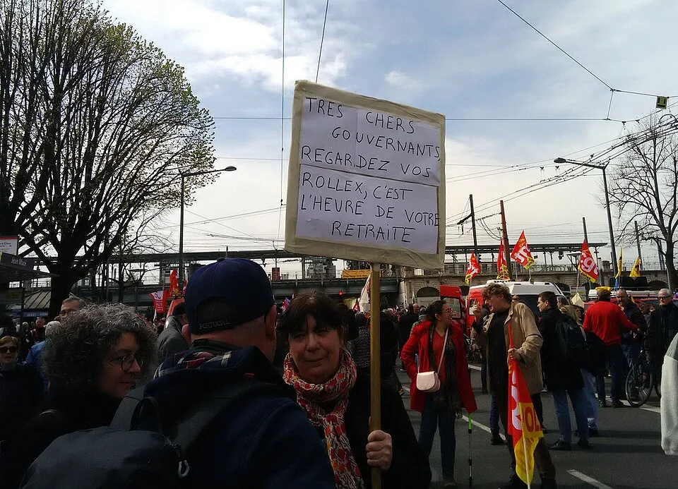 لافتة مظاهرة كُتب عليها «Très chers gouvernants, regardez vos Rollex, c'est l'heure de votre retraite»، صُوّرت في Lyon, فرنسا.