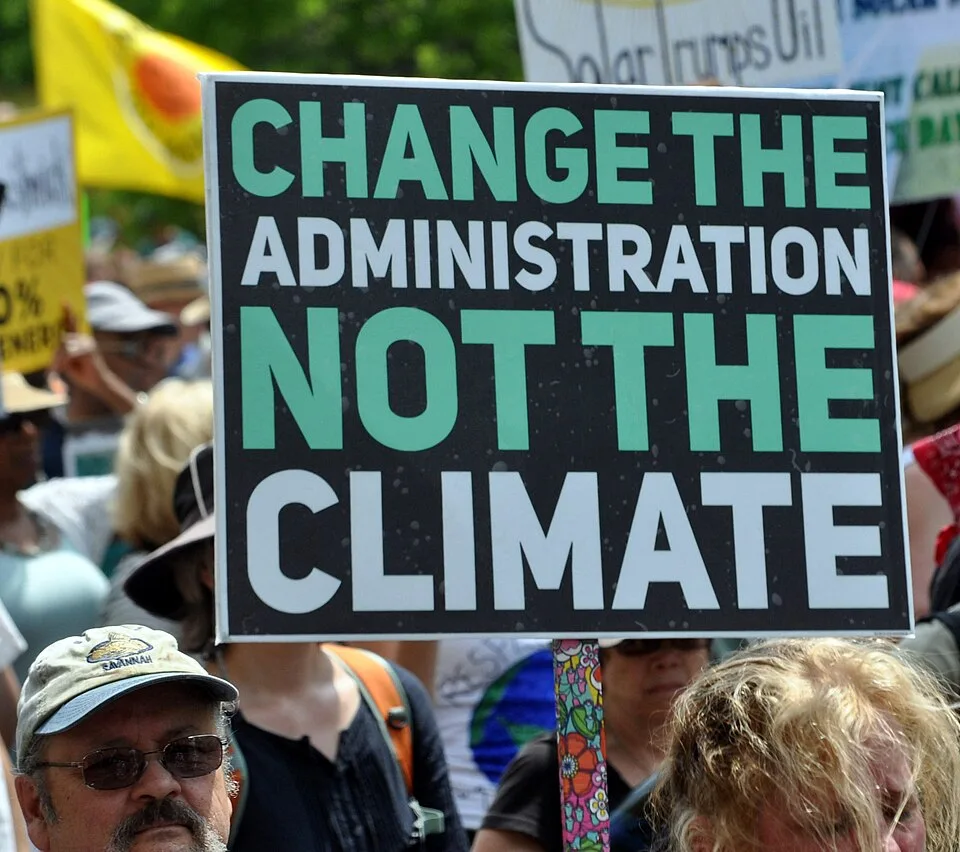لافتة احتجاج مكتوب عليها «Change the administration, not the climate»