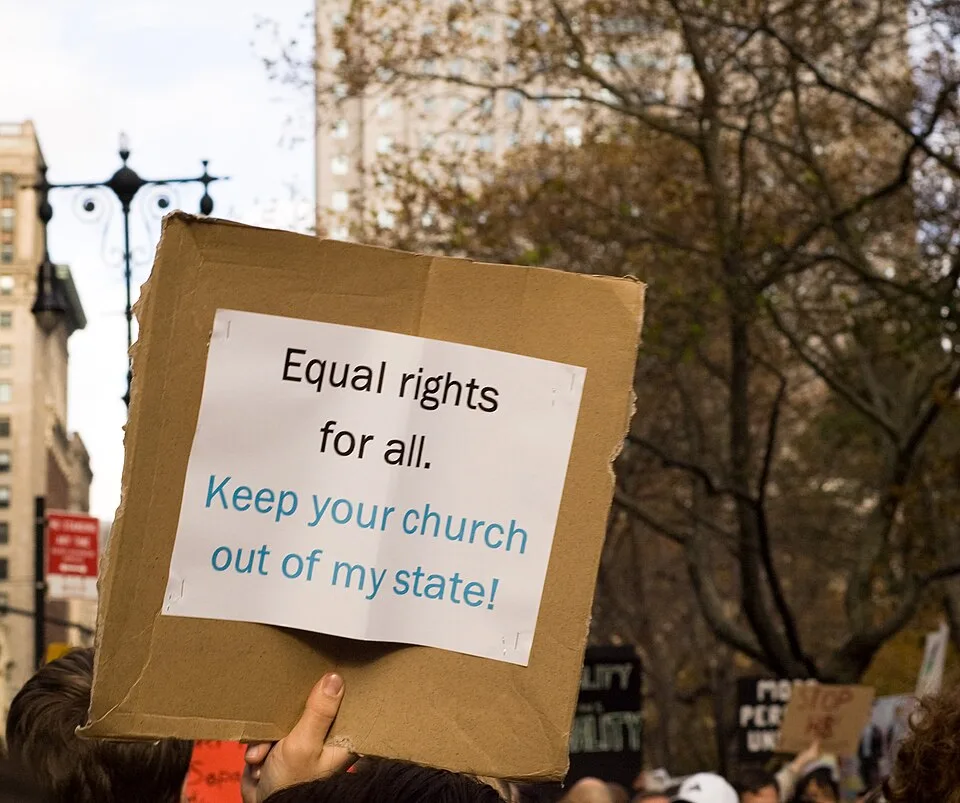 لافتة احتجاج مكتوب عليها «Hey, you got your church in my state!»