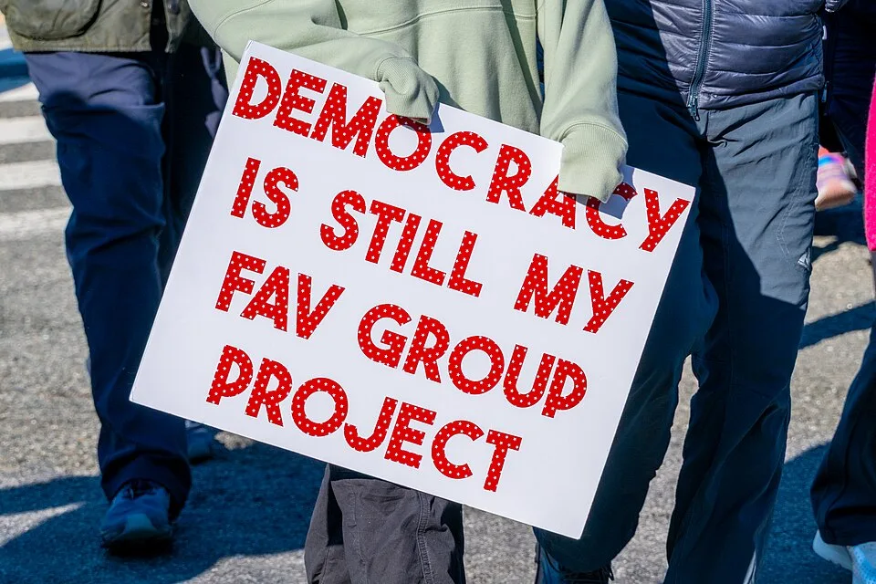 Pancarta con el texto «Democracy is still my fav group project», fotografiada en Washington, Estados Unidos.