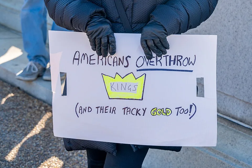 Pancarta con el texto «Americans overthrow kings (and their tacky gold too!)», fotografiada en Washington, Estados Unidos.
