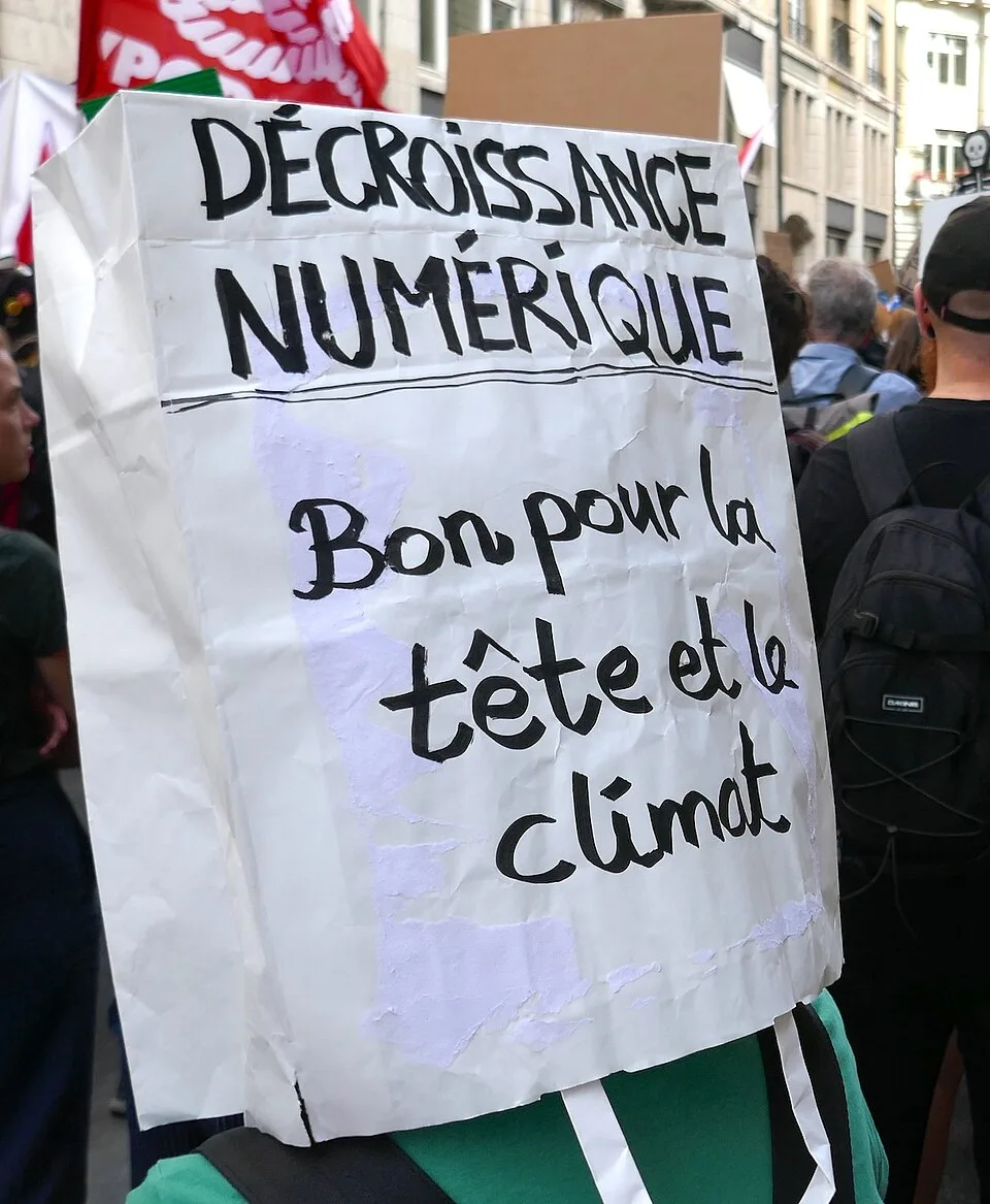 لافتة مظاهرة كُتب عليها «Décroissance numérique : bon pour la tête et le climat»، صُوّرت في Bern, سويسرا.