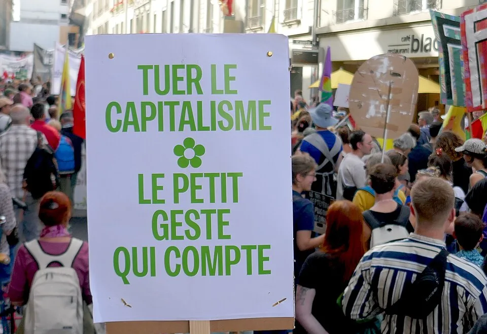 لافتة مظاهرة كُتب عليها «Tuer le capitalisme : le petit geste qui compte»، صُوّرت في Bern, سويسرا.