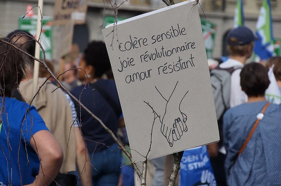Pancarta con el texto «Colère sensible, joie révolutionnaire, amour résistant», fotografiada en Bern, Suiza.