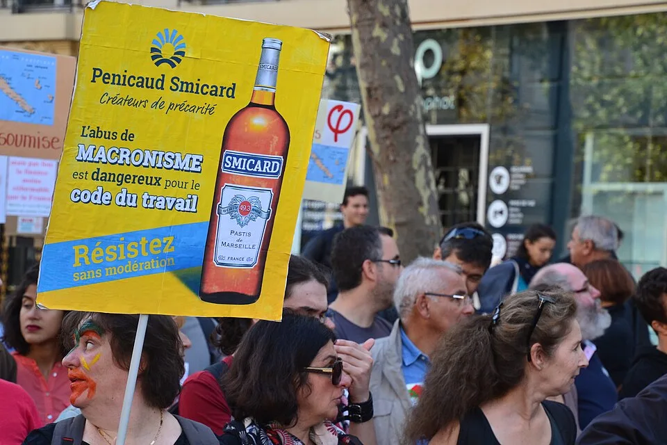 Protestbord met de tekst ‘Pénicaud Smicard, créateur de précarité. L'abus de macronisme est dangereux pour le code du travail. Résistez sans modération.’, gefotografeerd in Paris, Frankrijk.
