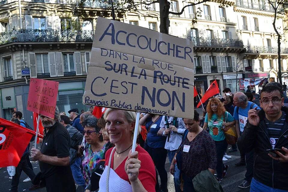 Protestbord met de tekst ‘Accoucher dans la rue, sur la route, c'est non. Pouvoirs publics dangereux !’, gefotografeerd in Paris, Frankrijk.
