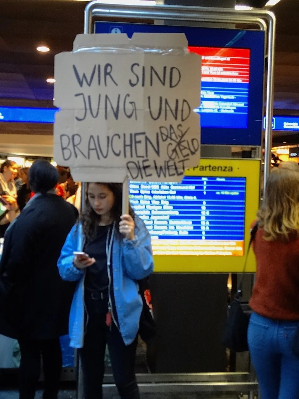 Pancarta con el texto «Wir sind jung und brauchen das Geld. Die Welt!», fotografiada en Bern, Suiza.