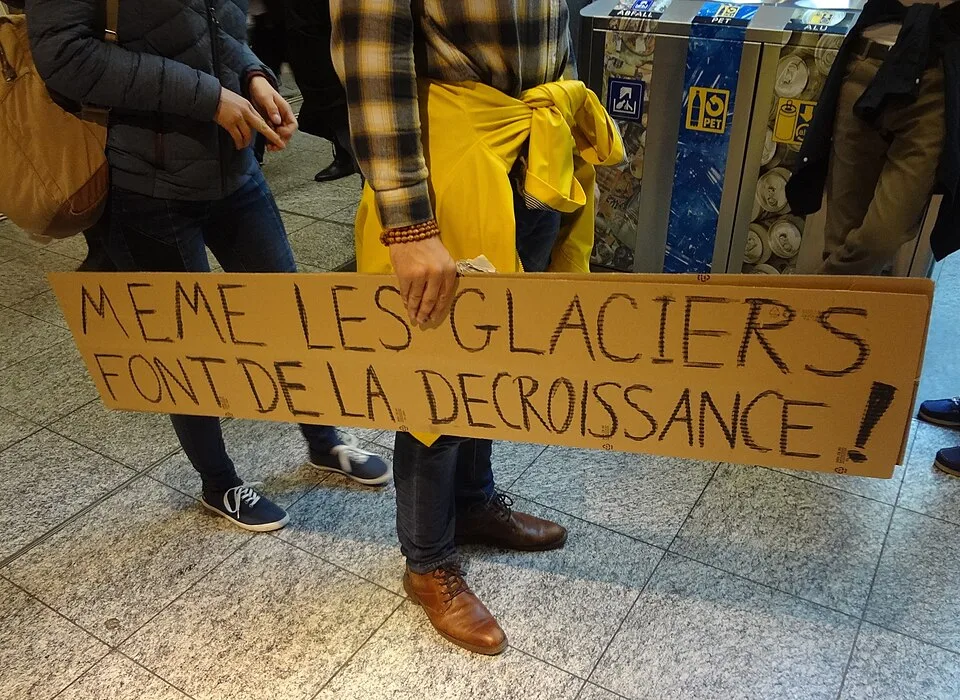Pancarta con el texto «Même les glaciers font de la décroissance !», fotografiada en Bern, Suiza.