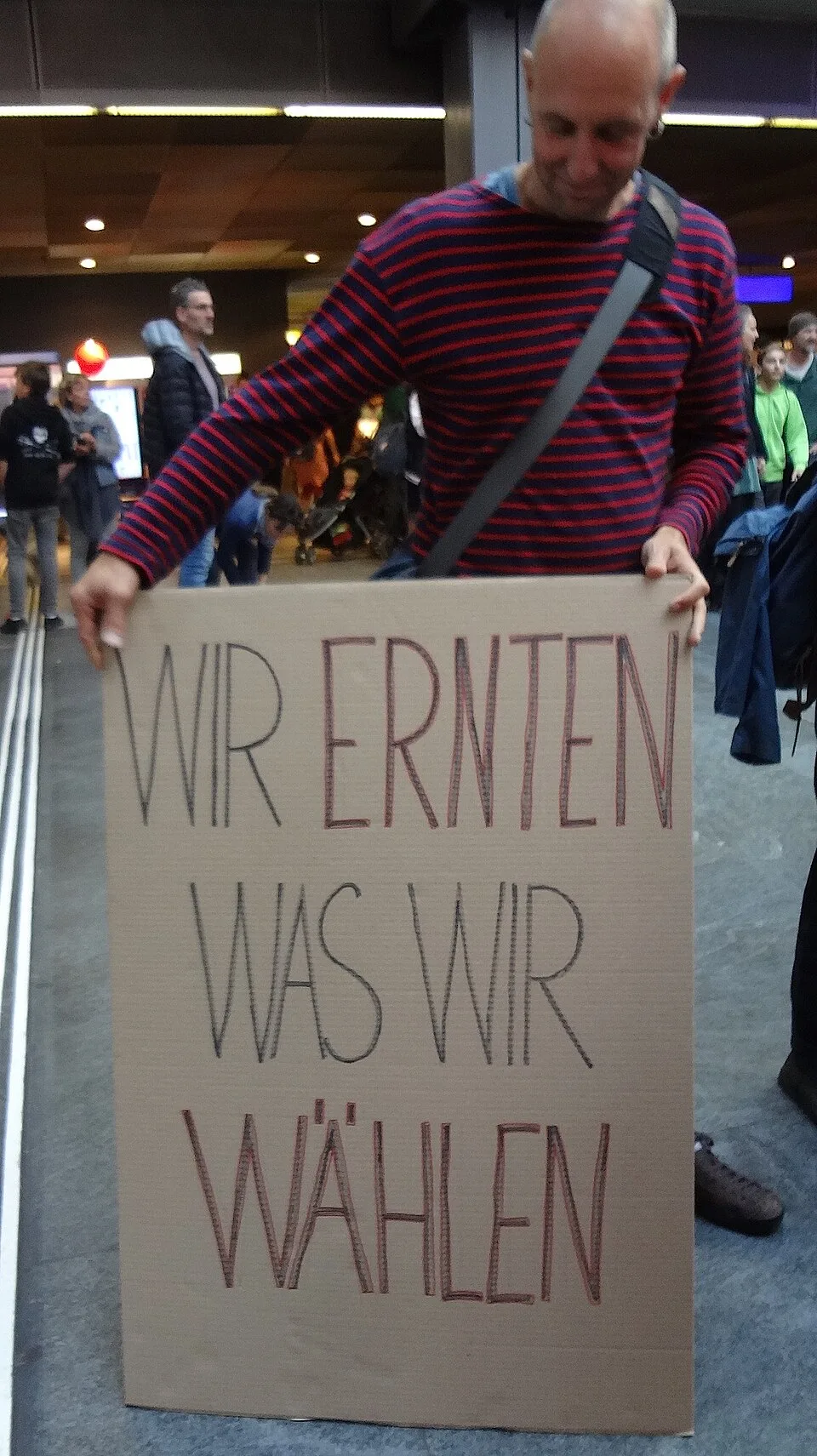 Pancarta con el texto «Wir ernten, was wir wählen», fotografiada en Bern, Suiza.