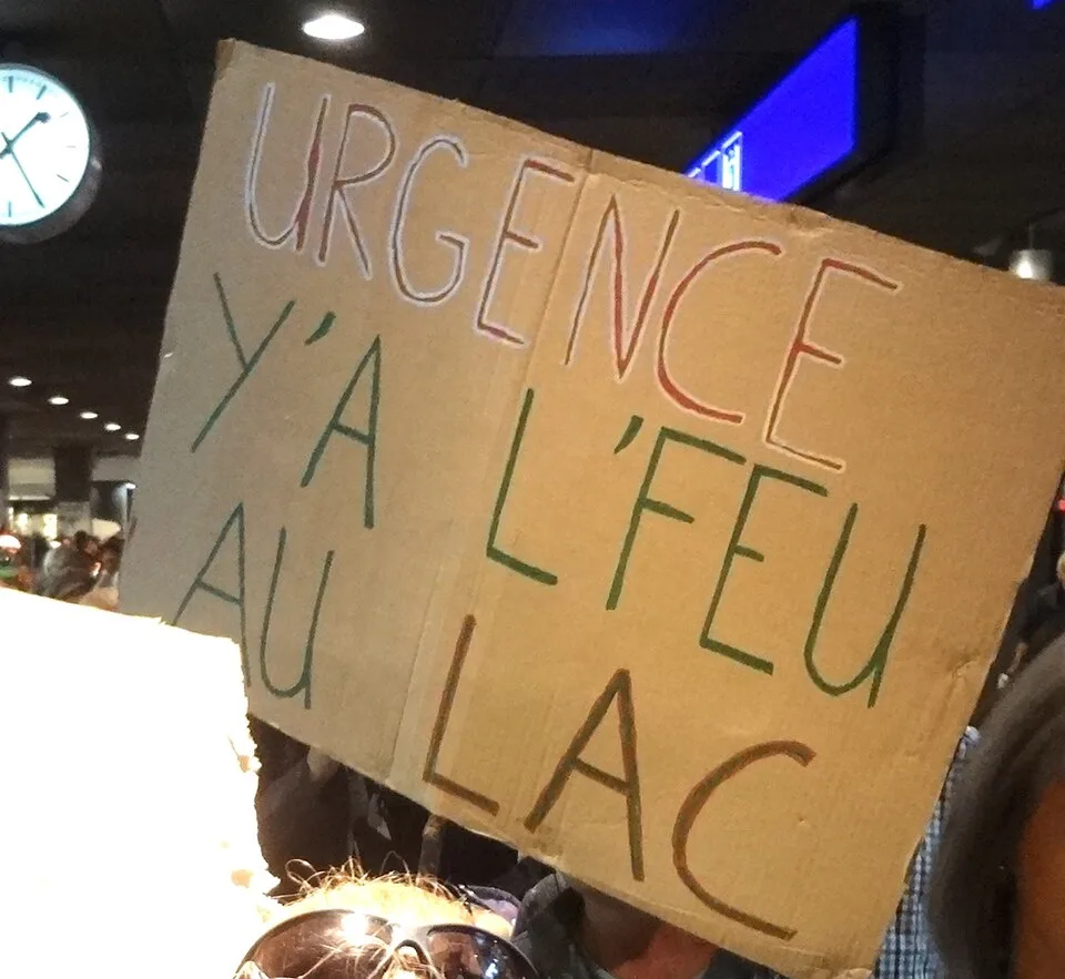 Pancarta con el texto «Urgence, y'a l'feu au lac», fotografiada en Bern, Suiza.