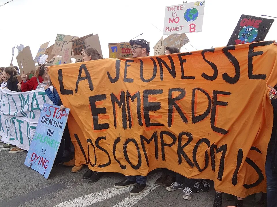Pancarta con el texto «La jeunesse emmerde vos compromis», fotografiada en Genève, Suiza.
