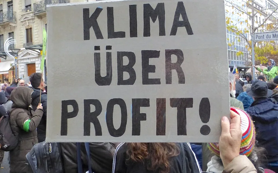 Pancarta con el texto «Klima über Profit!», fotografiada en Genève, Suiza.