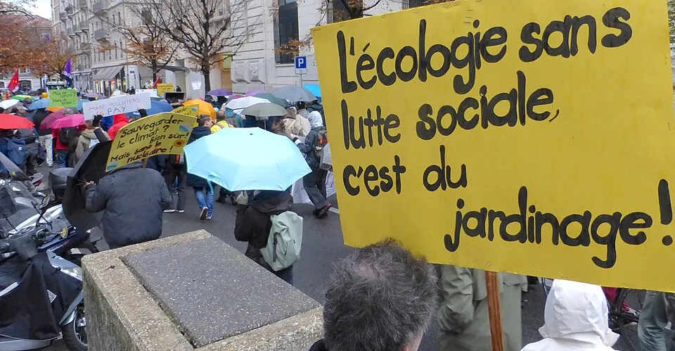 Pancarta con el texto «L'écologie sans lutte sociale, c'est du jardinage !», fotografiada en Genève, Suiza.