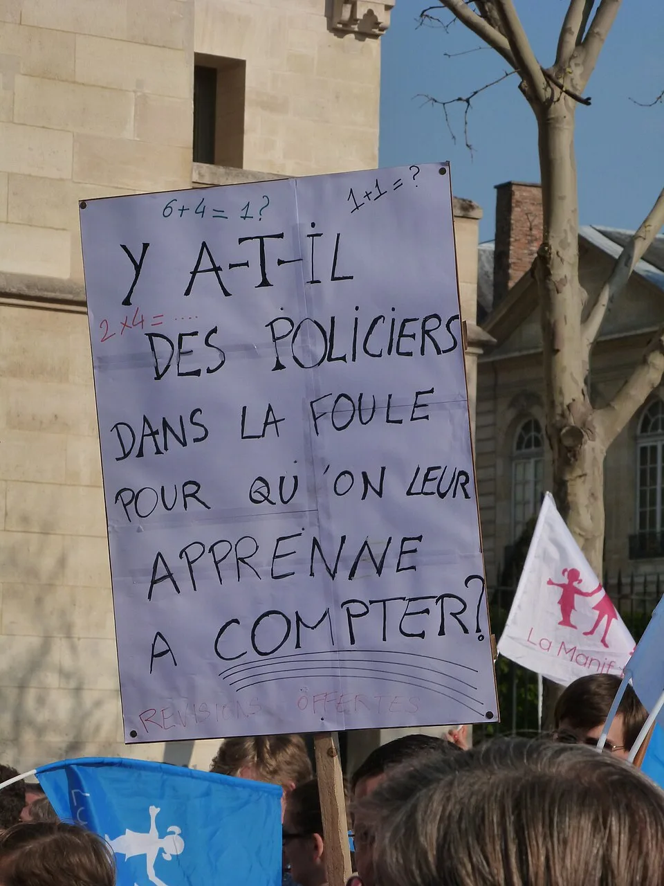 لافتة مظاهرة كُتب عليها «Y a-t-il des policiers dans la foule pour qu'on leur apprenne à compter ?»، صُوّرت في Paris, فرنسا.