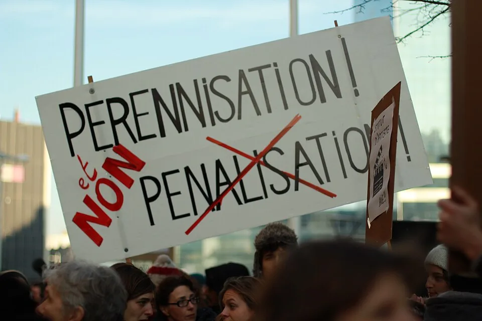 لافتة مظاهرة كُتب عليها «Pérennisation ! Non pénalisation !»، صُوّرت في Bruxelles, بلجيكا.