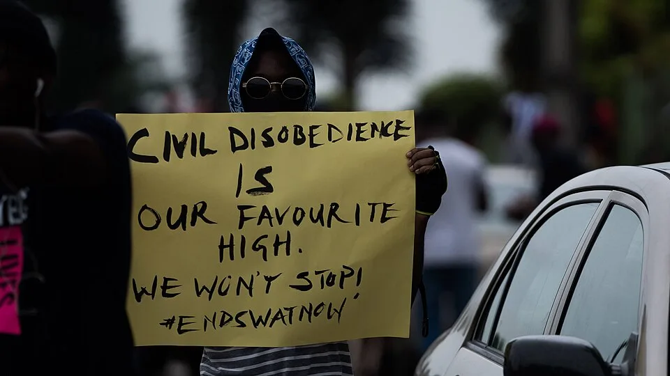 لافتة احتجاج مكتوب عليها «Civil disobedience is our favourite high. We won't stop!»