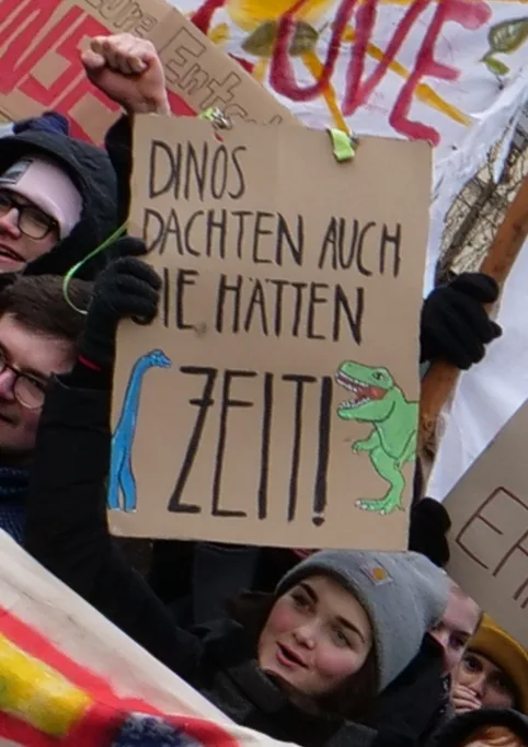 لافتة مظاهرة كُتب عليها «Dinos dachten auch, sie hätten Zeit!»، صُوّرت في Berlin, ألمانيا.