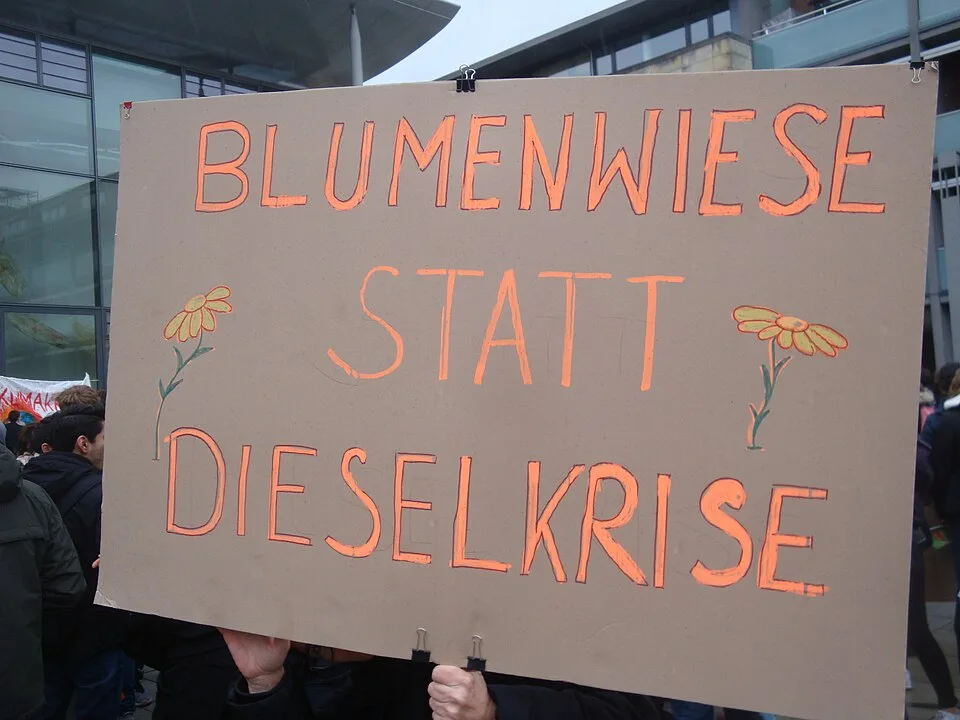 لافتة احتجاج مكتوب عليها «Blumenwiese statt Dieselkrise»