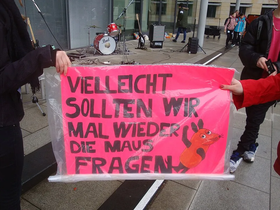 لافتة احتجاج مكتوب عليها «Vielleicht sollten wir mal wieder die Maus fragen»