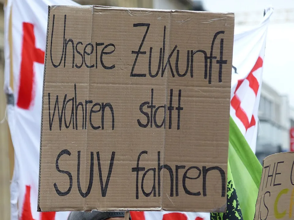Pancarta de protesta que dice «Unsere Zukunft wahren statt SUV fahren»