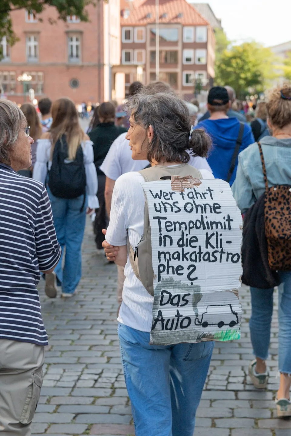 Pancarta de protesta que dice «Wer fährt uns ohne Tempolimit in die Klimakatastrophe? Das Auto»