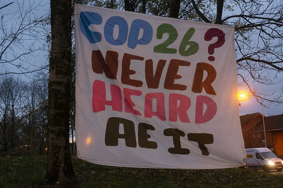 Pancarta de protesta que dice «COP26? Never heard ae it»