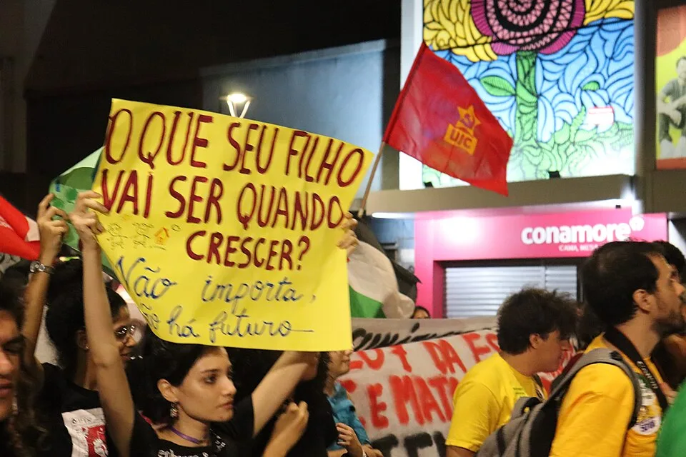 Pancarta de protesta que dice «O que seu filho vai ser quando crescer? Não importa, não há futuro»