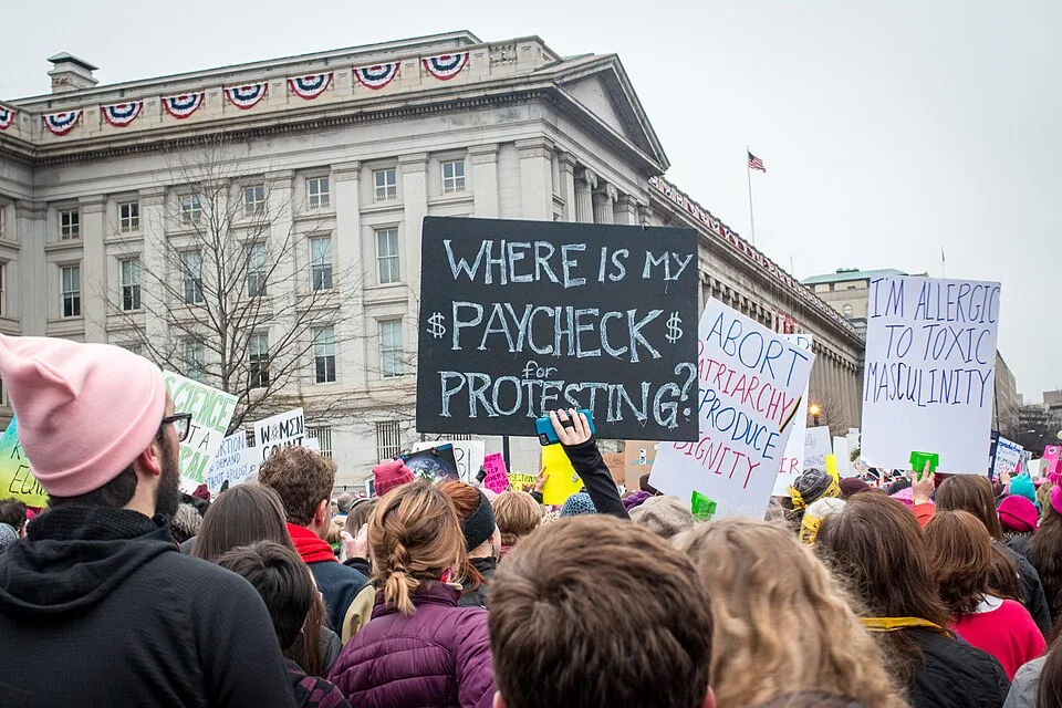 لافتة مظاهرة كُتب عليها «Where is my #PAYCHECK$ for protesting?»، صُوّرت في Washington, الولايات المتحدة.