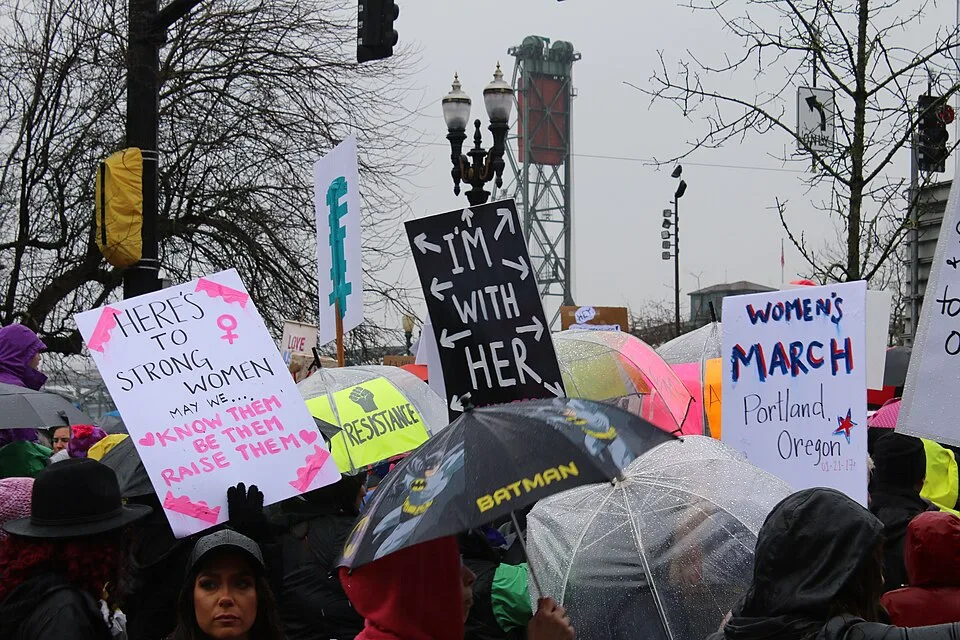 Protestbord met de tekst ‘Here's to strong women. May we know them, be them, raise them.’, gefotografeerd in Portland, Verenigde Staten.