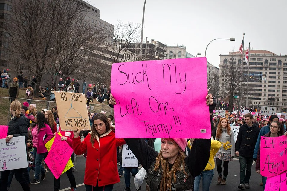 Protestbord met de tekst ‘Suck my left one, Trump!!!’, gefotografeerd in Washington, Verenigde Staten.