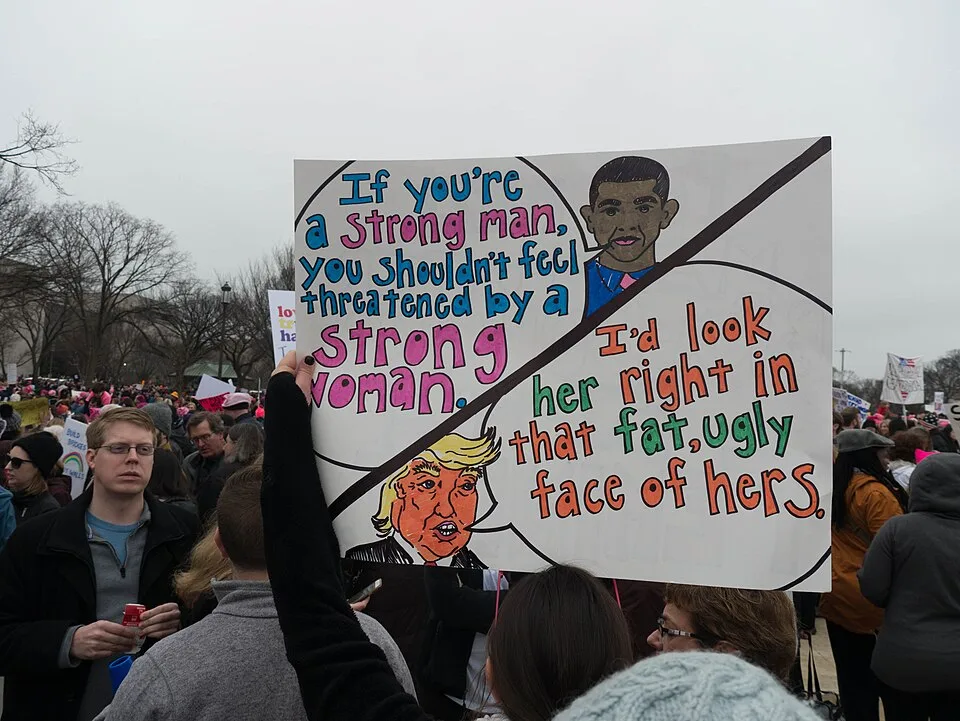 Protest sign reading “If you're a strong man, you shouldn't feel threatened by a strong woman”, photographed in Washington, United States.